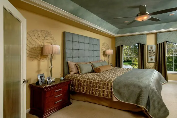 a bedroom with a large bed and a ceiling fan