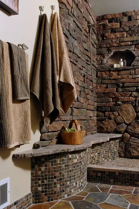 a bathroom with stone walls and a shower