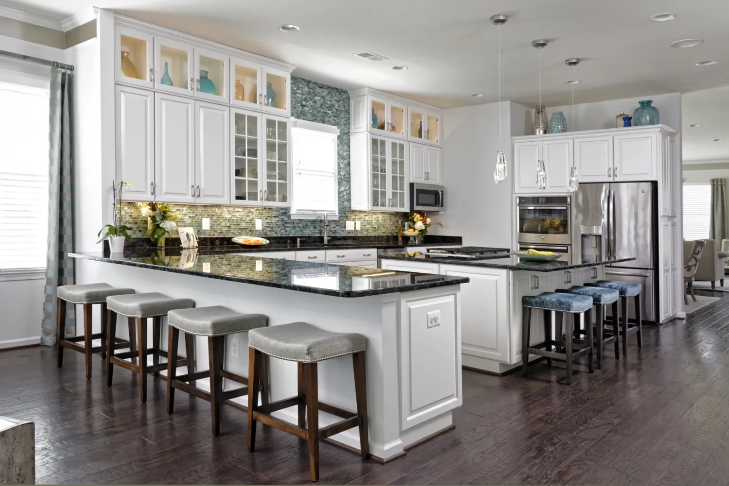 a kitchen with white cabinets and a bar stools